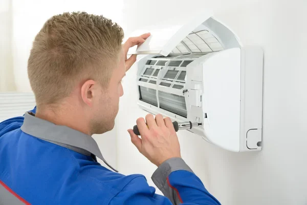 depositphotos_62699483-stock-photo-technician-repairing-air-conditioner